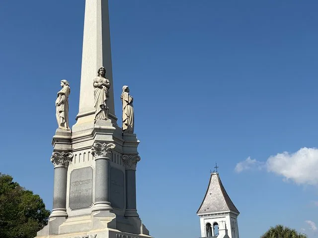 A tall monument with statues in Metairie Cemetery.