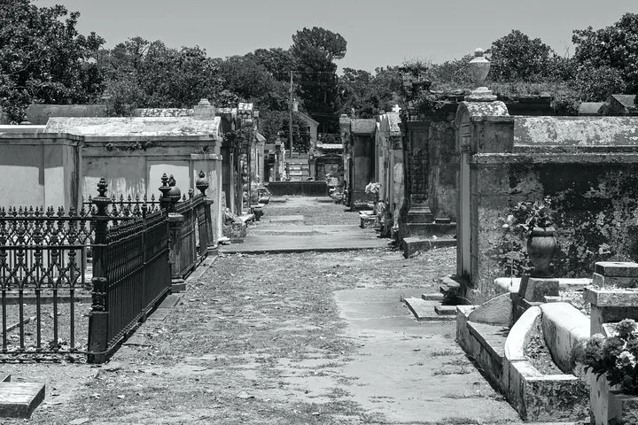 A black and white image of above-ground tombs at Metairie Cemetery.