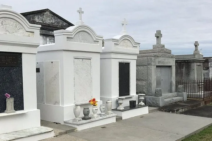Row of above-ground white and grey marble tombs in a cemetery.