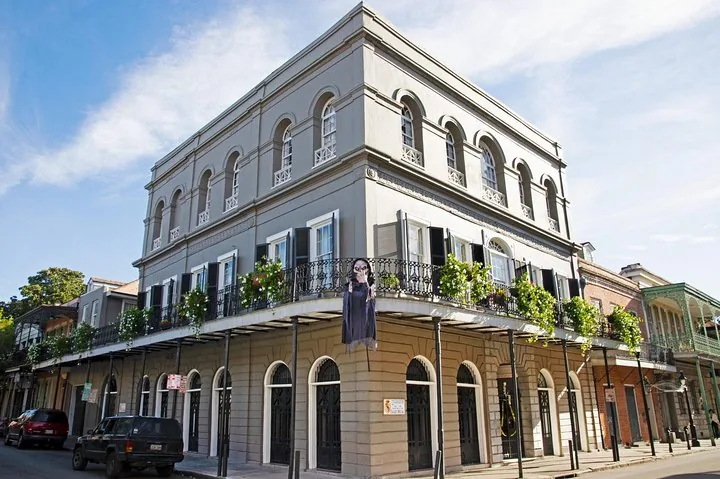A multi-story gray building with a wraparound balcony in New Orleans.